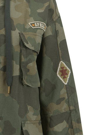 close-up-of-a-camouflage-jacket-with-a-dark-drawstring-a-flap-pocket-a-spell-embroidered-patch-on-the-chest-and-a-diamond-shaped-embroidered-patch-on-the-sleeve-set-against-a-plain-white-background