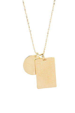 Close up back view of Spell’s Taurus Stargazer Zodiac Necklace charms. One charm is of a rectangular shape and an inspirational quote while the other charm is circular the brand name