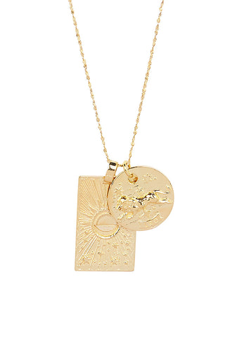 Close up front view of Spell’s Leo Stargazer Zodiac Necklace charms. One charm is of a rectangular shape and features a sun with stars while the other charm is circular and features the Zodiac label and icon.